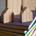 drewniane miniatury domów na stosie książek